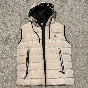 Väst - En unik moncler väst men snygga detaljer, gillade aldrig färgen därför säljs den. Två stora fickor, 1 inne ficka, stor luva och en dragkedja som knäpper hela västen, aldrig använd skit bra skick bästa kvalite!