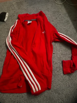 Röd Adidas zip up hoodie - Jätte fin adidas Hoodie med dragkedja lite annan för i verkligheten än på bilden