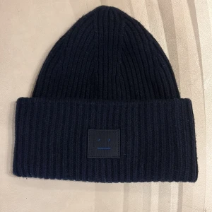 Mörkblå Acne mössa! - Säljer min mörkblå Acne mössa då den inte kommer till andvändnng. Den är i jättefint skick och bara andvänd ett fåtal gånger!