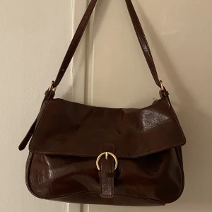 Brun väska - Vintage inspirerad brun väska. Det tillkommer både ett långt och ett kort band som man kan justera lite hur man vill. Aldrig använd