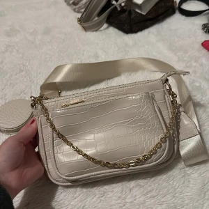 Vit väska med avtagbar band  - Säljer den här väskan som har avtagbara band och kan användas som en axelremsväska samt vanlig handväska 