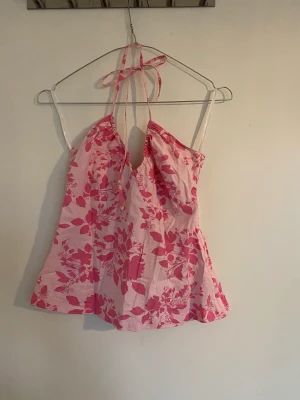 Somrig halternecktopp - Söt halterneck med blommigt mönster. Snören som man knyter i nacken. Nästan helt oanvänd 
