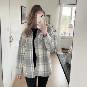 Vårkappa  - En rutig vit/grå kappa.