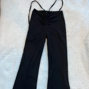 Svarta bootcut byxor - Svarta bootcut byxor med söta band från Bikbok that kinda gives me Euphoria vibes🪩. Passar stl xxs-m.