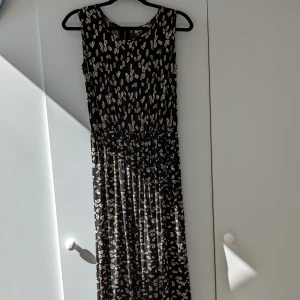 Lång sommarklänning  - Lång sommarklänning i bomull med dragkedja i nacken och resår i midjan. Lagad fram till vänster under axeln med vlieselin. Fulllång på mig, 170cm lång