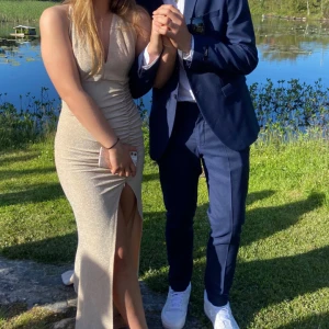 Glittrig balklänning - Säljer nu min fina balklänning jag hade förra året. Den är beige med lite glitter och en lång slits på sidan. Endast använd vid ett tillfälle. Köpt på SHEIN för ungefär 600kr. 