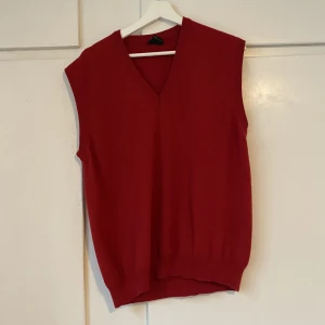 Röd stickad väst  - Röd väst i ull. Ungefär storlek M men jag är XS och har haft den oversized.  Made in Italy. 