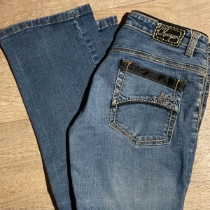 Lågmidjade jeans - Jättefina lågmidjade Morgan de toi jeans med guldiga detaljer. Innebenslängd ca 79, midja tvärs över ca 39💓 Har några lösa trådar men inget som syns och kan fixas lätt. Kom privat för fler bilder eller frågor💞