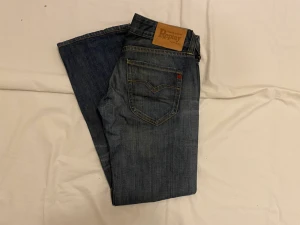 Replay jeans - Replay jeans, köpte fel. det är dam jeans de är lågmidjade samt vida vid benen. Midja 39 cm. Benöppning: 23cm. Innerbenslängd: 76cm. Från skrev till midja: 19 cm