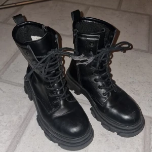 Vintersko - Svart vintetsko som är använd en säsong. Dragkedja på insidan. Skosnörena är lite fransiga  längst ut. Zoey storlek 37