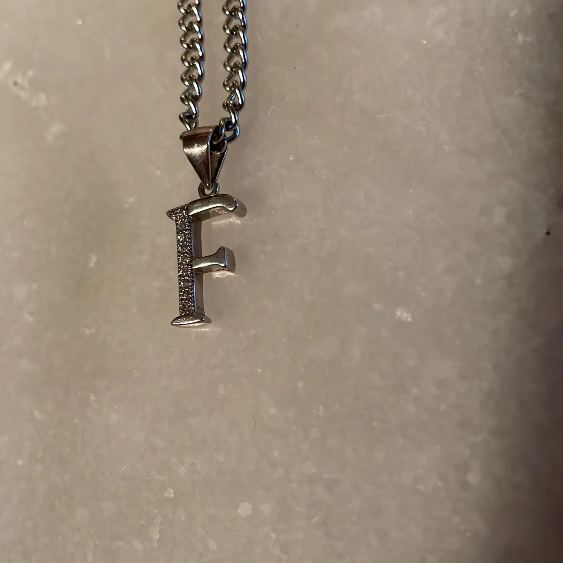 Halsband med ett silver ”F” - 90