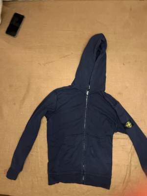 Vi säljer nu denna zip hoodie från Stone Island. Produkten är avsedd för yngre killar där storleken är 12y. Tröjan har använts en del men är fortfarande i ett bra skick. Nypris: Omkring 2000kr. Vårt pris: 500kr. Kontakta oss för fler bilder eller frågor!