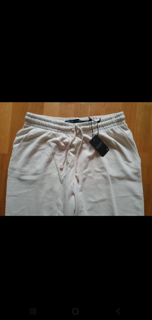 Byxor - Vit/creme färgad. Oanvända byxor. Säljes pga korta i längden. 89 cm i längd  55 cm bredd