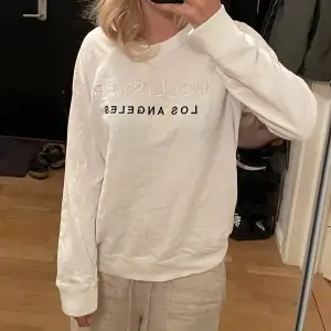 Vit sweatshirt från hollister med inbroderad text. 