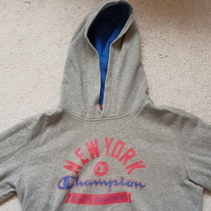 Champion hoodie - Grå Champion hoodie med små hål på båda händer.