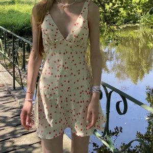 Klänning med körsbär, stl S - Säljer denna supersöta klänning ifrån Zara. Det är en kort klänning på mig som är 1,70 cm lång. Superfint skick, precis som ny! 