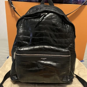 Saint Laurent Crocodile Backpack - SLP ryggsäck i den vanliga storleken. Nypris ligger på 21000kr, skicket är 9/10. Knappt använd alls.