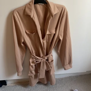 Beige cargoklänning - Aldrig använd cargoklänning med knytning i midjan. Ifrån Nelly.com