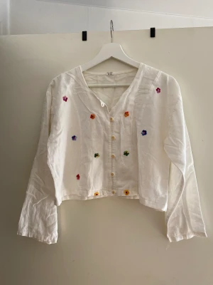 Vintage blus med blommor  - Vintage bomulls blus med små broderade blommor och knappar.  Har kortats av!   Har en liten fläck på baksidan av ena ärmen, går förmodligen bort i tvätten. Slutar ungefär i midjan.  