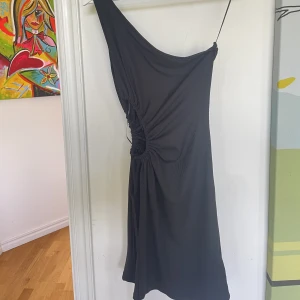 Ribbad klänning  - Ribbad oneshoulder klänning, stretchigt material och cutouten i midjan kan man dra åt med snören. Aldrig använd🥰
