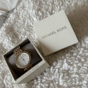 Michael Kors klocka  - Mycket fin klocka äkta Michael kors. Allt på bilden följer med. Klockan är i stål och i guld färg. 