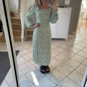 Grönblommig midiklänning - Grön midiklänning, alltså går halvvägs ner på vaderna (jag är 165 cm). Väldigt bra skick, bara använd några fåtal gånger!  På sidan finns en slits.  Köp från zalando - märket Fashion union.