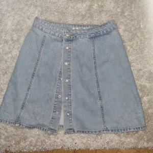 Jeanskjol Pull & Bear - Snygg jeanskjol med knäppning från Pull & Bear, slutar precis innan knäna i storlek M men sitter snarare som S/XS. Säljes pga för liten