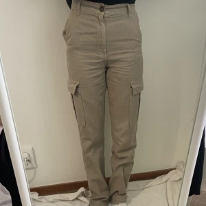 cargobyxor - Säljer ett par beiga cargobyxor från stradivarius i storlek 32. Dessa byxor är högmidjade men väldigt sköna. 