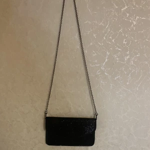 Glittrig kuvertväska  - En fin glittrig kuvertväska använd cirka 1-2 gånger. Säljer pga att den inte kommer till så stor användning. Priset kan diskuteras.  Obs! Köparen står för frakten och jag står inte för fraktens slarv.