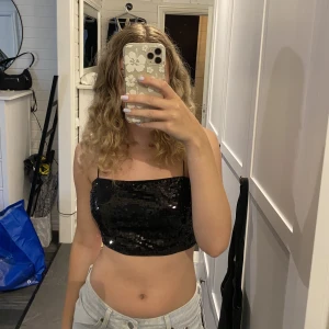 svart paljett topp - snygg svart paljett topp, passar perfekt till fest! säljer pga att den inte kommer till användning. aldrig använd. den är i 38 men passar mig som vanligtvis har 36.