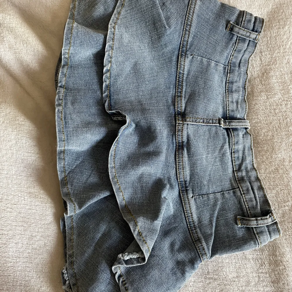 Kort jeanskjol med volanger i storlek S men passar även som XS. Finns inbyggda shorts som gör att man inte flashar nåt!🙌Har aldrig använts och är i god skick! Däremot sitter byxknappeb lite löst.. Kjolar.