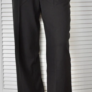Svarta kostymbyxor med raka ben - Nypris: 569kr Aldrig använd, tiden för returnering gick ut. Normal i storleken. Resår i midjan. Har fickor men svårt att få fram på bild.