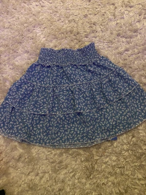 Blå blommig Volangkjol  - Jättefin blå Volangkjol som är införskaffad förra året men aldrig använd😊i nyskick.