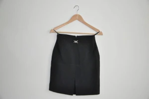 Svart kjol - Pris efter överenskommelse, mängdrabatt kan ges. En svart kjol med mönstrad textur och ett silvrigt spänne