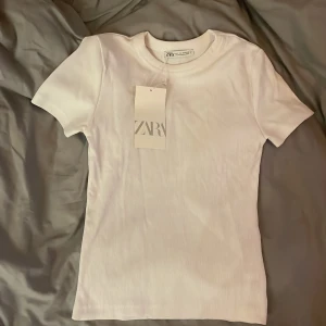 Vit Zara t-shirts  - Helt ny. Aldrig använd. Storleken är S. T-shirt är ribbad vilket är super snyggt! 👌