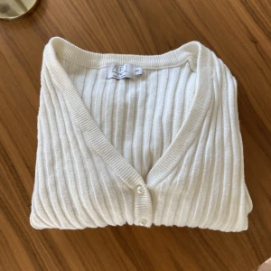 Tröja - Vit kofta med pärlor som knappar. Passar även xxs och s beroende på vilken passform man är ute efter.