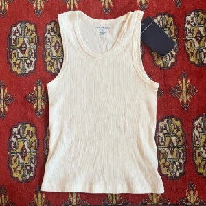 Vit tank topp - Vit ribbad tank topp från Brandy Melville, aldrig använd nypris: ca 160kr