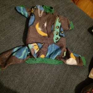 Söt hund overall med dragsko  - Ryggmått ca 35cm, framben (inkl mudd) ca 15cm, bakben (inkl mudd) ca 20cm. Dragsko över länden. Hemmasydd (inte av mig, dock)i fleece, aldrig använd