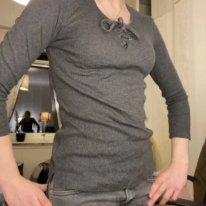 Snygg tröja! - Snygg grå långärmad tröja men knyte på bröstet! Bra skick. Säljer pågrund av att jag inte använder den! Köpte den för 199kr men säljer nu för 50kr inklusive frakt!💗