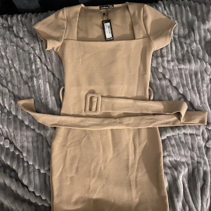Festklänning - Superfin klänning från Boohoo i storlek 36 som går att ha till både fest och vardags, har en slits vid ena sidan av benet och är ungefär till knäna. Aldrig använd endast provad!