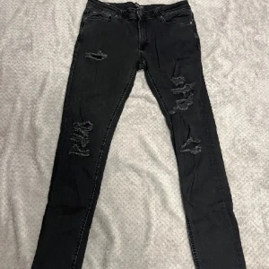 Jeans från Jack & Jones - Svarta slitna jeans från Jack & Jones med storlek W32 L34, knappt använda. Pris kan diskuteras vid snabbaffär. 