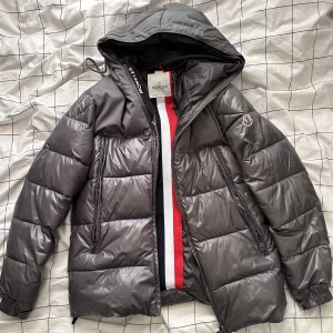 Moncler jacka - Säljer min pojkväns moncler jacka då han köpt en ny till vintern, de är en grå/silver jacka som endast är använd några gånger förra vintern så den är som ny. De är en S men den är lite större i passformen så passar nog en M också
