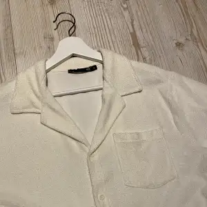 Vit kortärmad skjorta i frotématerial. Inte använd mycket!🤍