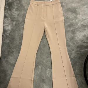 Kostymbyxor - Säljer mina jättefina beiga kostymbyxor från Chiquelle eftersom de inte passar mig. Aldrig använt, prislappen sitter kvar. De är storlek 38 står det men är mycket mindre i storleken tycker jag, mer av en 34 kanske 36 är de. 