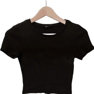 Svart t-shirt - Svart lätt ribbad t-shirt från even&odd. Tyvärr för liten för mig. Använd en gång så den är i nyskick utan några anmärkningar. Jag säljer den även i vit!