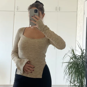 Tröja med slits - Jättefin tröja med slits i midjan. Är även slits längst ner på ärmen vilket är så fint🤍 Fyrkantig urringning i en guldig/bronsig färg🤍storlek xs från Gina Tricot