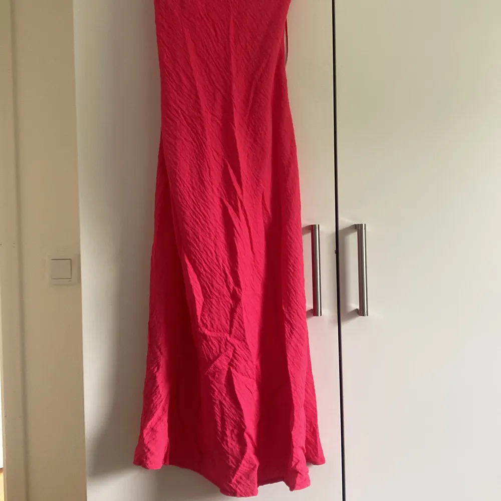 En knallrosa långklänning som har knytning där bak och öppen rygg. . Klänningar.