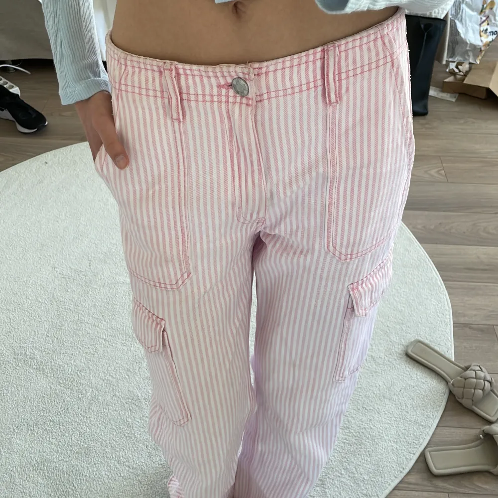 Säljer dessa rosa randiga cargopants ifrån zara. Har sprättat upp sömmen längs ner så de blev längre (visade på 3:e bilden). Kontakta vid intresse eller fler bilder!. Jeans & Byxor.