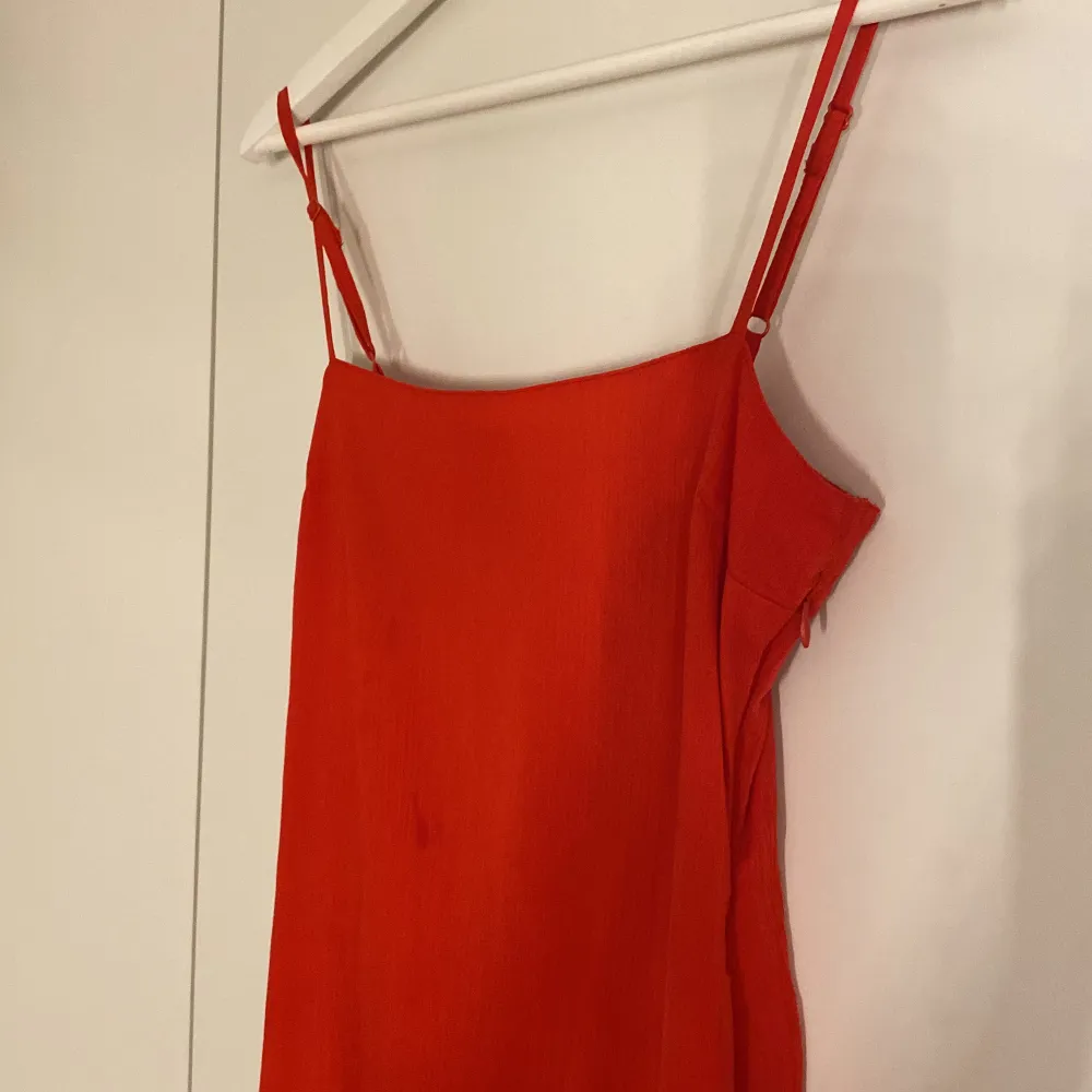 Röd enklare lång klänning med hög slits. Köpt för ett år sen från ASOS och använd 1 gång. Har en liten fläck på bröstet som lätt går bort i tvätten. Jag är 1,70 lång och oftast M, tror den passar en S bättre.. Klänningar.