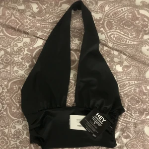 Svart halterneck festtopp nelly  - Säljer en ny och oanvänd svart halterneck topp i strl S ifrån nelly. Prislapp finns kvar. 